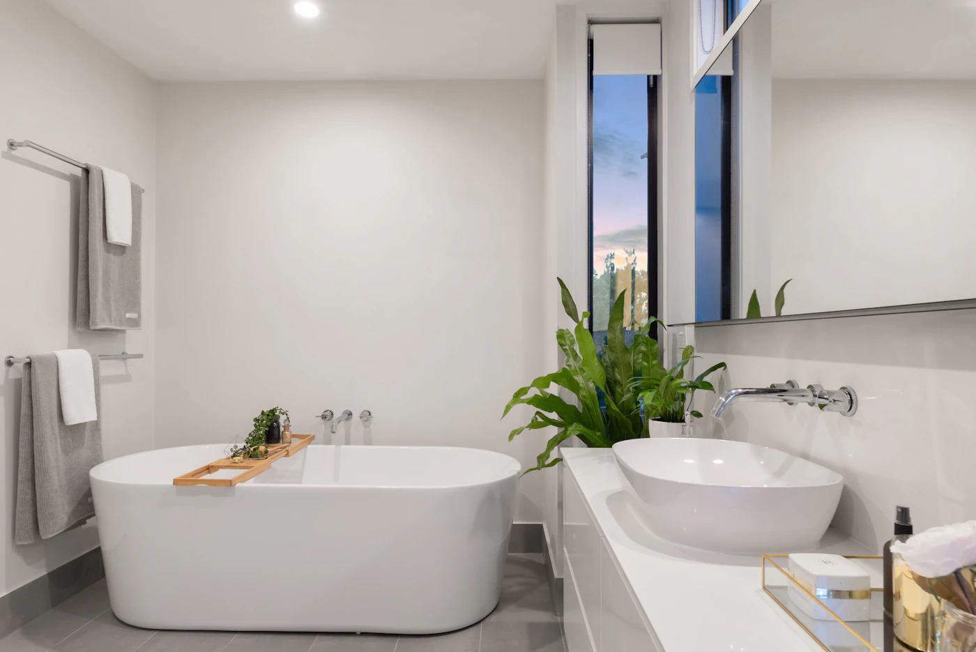 Bright modern bathroom with a freestanding bath, white basin and wall-mounted taps